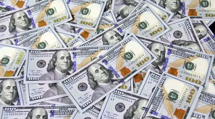 Pile of US hundred dollar bills depicting financial success and wealth.