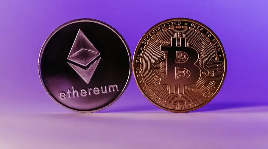 Close-up of Ethereum and Bitcoin coins symbolizing cryptocurrency and blockchain technology against a purple backdrop.