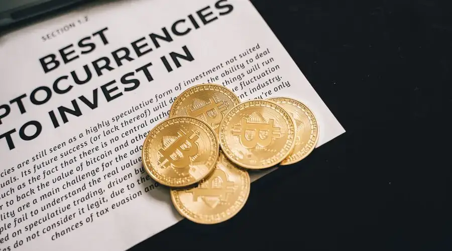 Close-up of Bitcoin coins on investment document promoting cryptocurrencies.