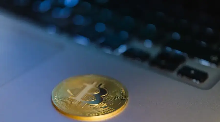 Close-up of a Bitcoin coin on a laptop, symbolizing digital currency and technology.