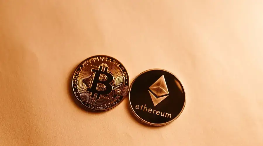 Bitcoin and Ethereum coins depicted on a soft yellow background for cryptocurrency and finance themes.