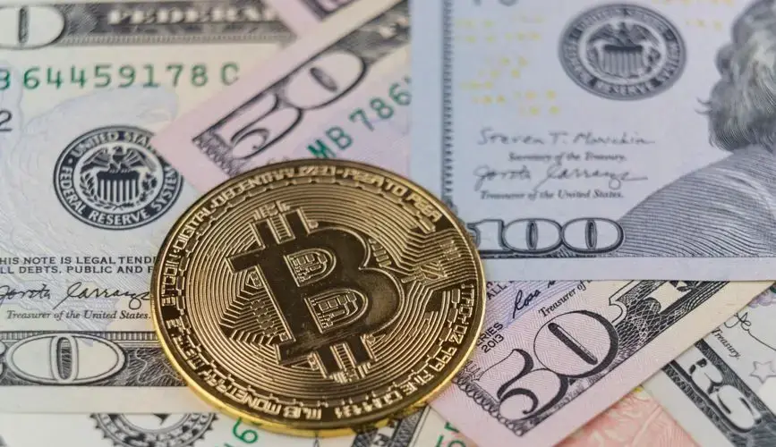 Close-up of a Bitcoin coin on US dollar banknotes, symbolizing cryptocurrency and traditional finance.