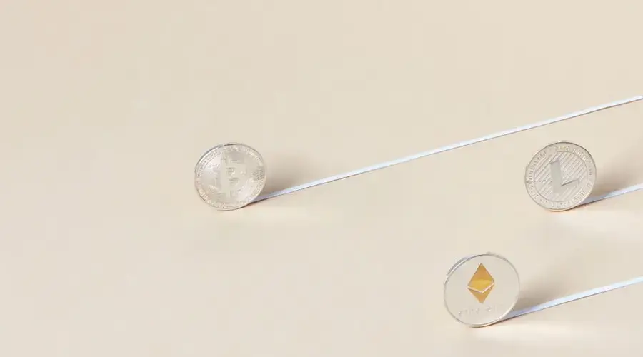 Minimalist studio shot of Bitcoin, Ethereum, and Litecoin coins aligned for a conceptual finance image.