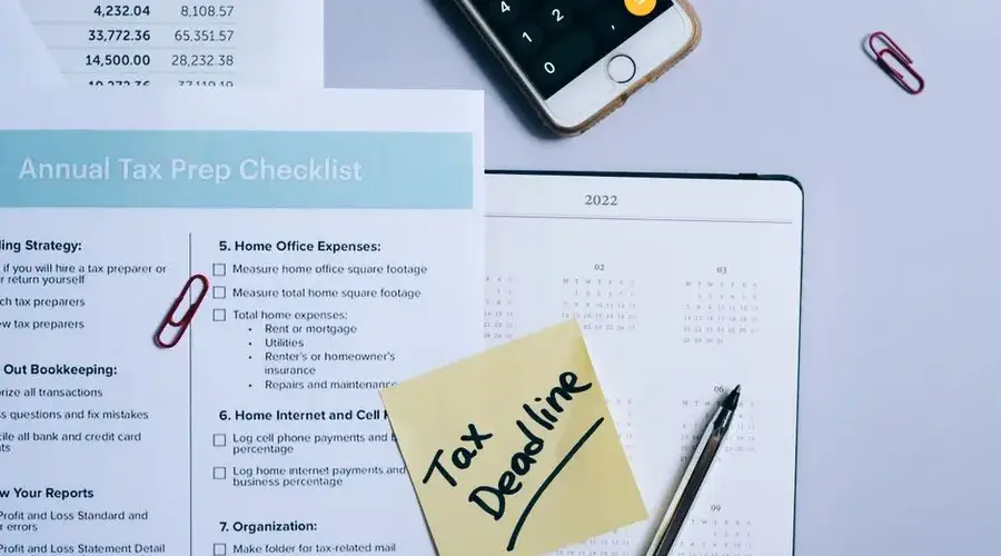 Organized tax preparation setup featuring checklist, calendar, and smartphone calculator for effective planning.