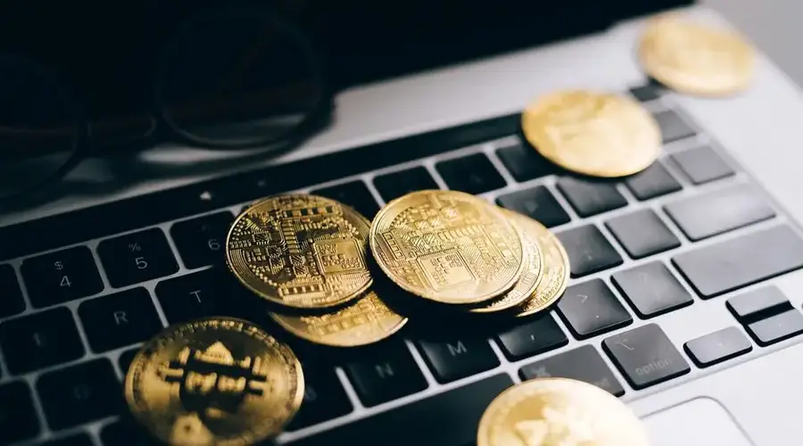 Close-up of gold bitcoins on a laptop keyboard symbolizing digital currency and technology.