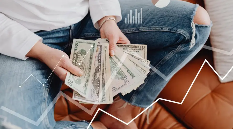 Person with dollars in hand, sitting, financial graphics overlay showing growth.