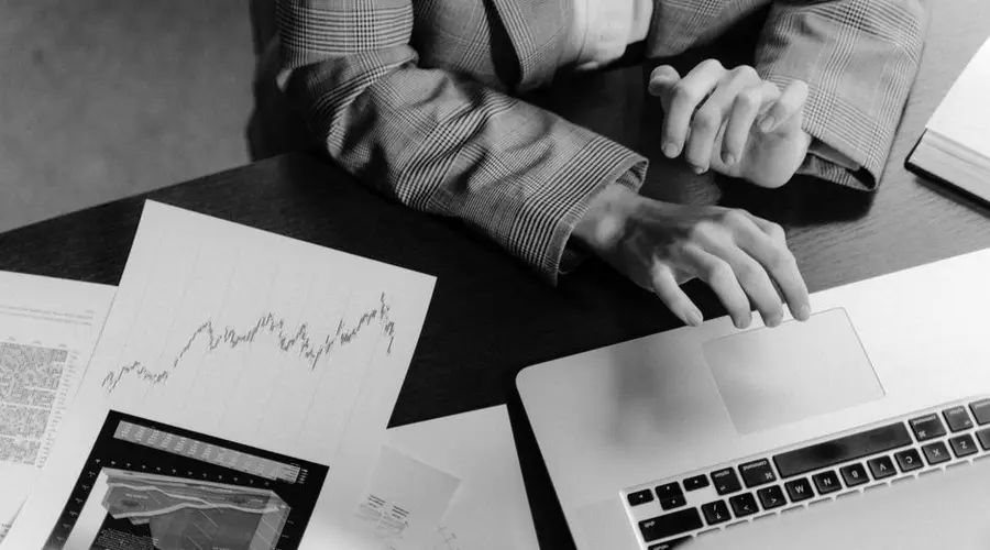 Focused workspace with business charts and laptop for financial analysis.