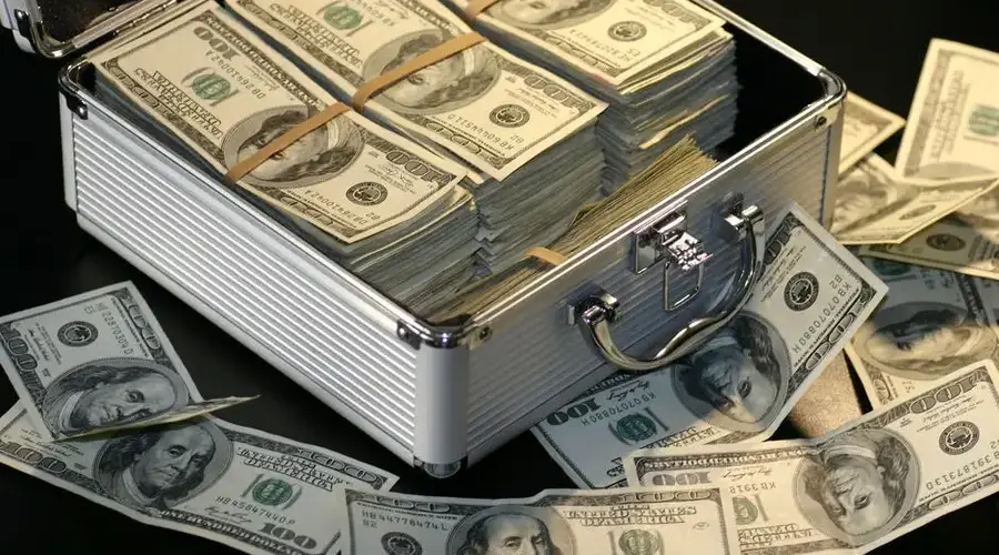A metallic briefcase full of US dollar bills, symbolizing wealth and investment.