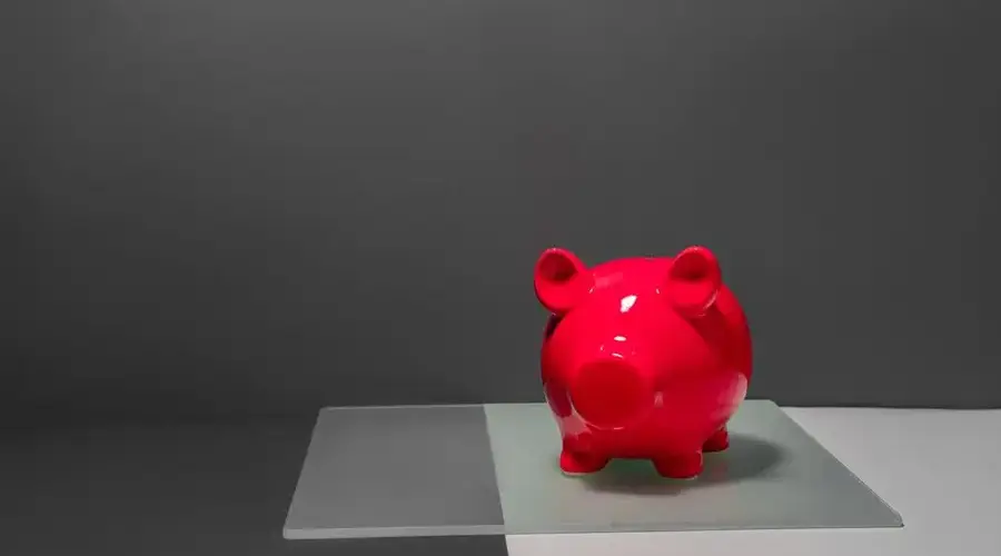 A vibrant red piggy bank against a minimalist and contrasting studio background, ideal for finance themes.