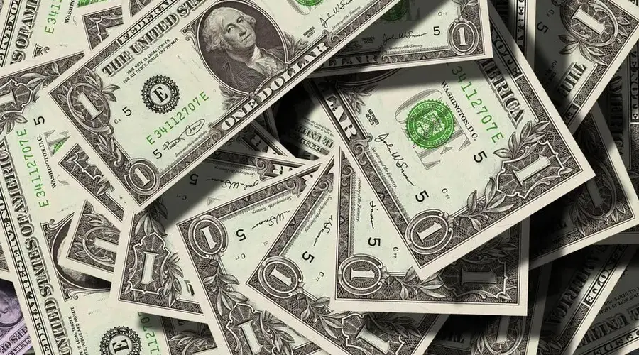 Close-up of scattered US dollar bills symbolizing finance and wealth.