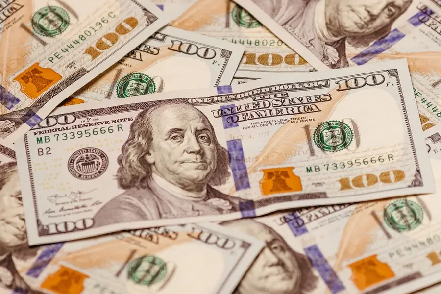 Close-up view of multiple US hundred dollar bills showcasing Benjamin Franklin.