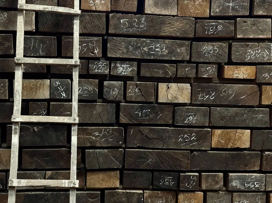A pile of marked wooden timber with a ladder leaning against it in Panchkula, India.