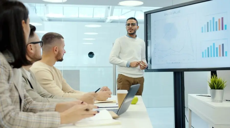 Business team in a modern office, discussing charts during a presentation.