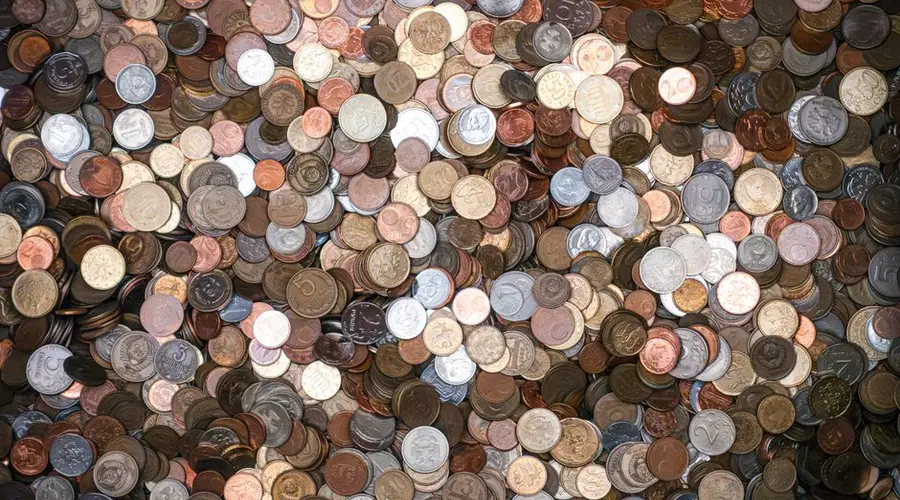 A diverse pile of various currencies' coins, offering a rich texture and metallic shine.