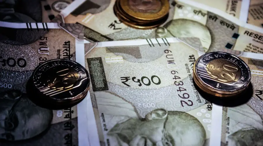 Detailed close-up of Indian currency notes and coins, featuring Mahatma Gandhi portrait.