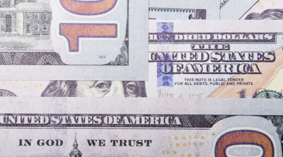 Detailed close-up of layered US dollar banknotes focusing on geometric patterns and financial concept.