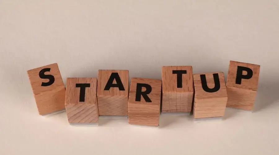 Wooden blocks forming the word 'STARTUP' on a neutral background, symbolizing new business ventures.