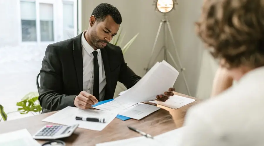 Professional businessman reviewing documents at a desk in a modern office setting.