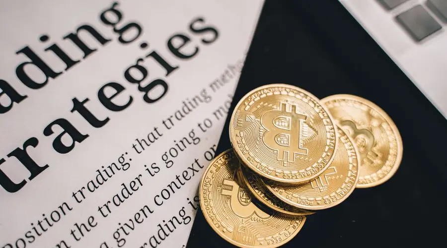 Close-up of gold Bitcoin coins on a trading document, symbolizing investment and cryptocurrency market strategies.