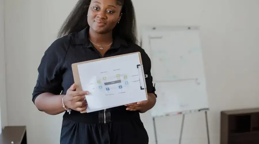 Confident woman giving a presentation with visual aids in a modern office environment.