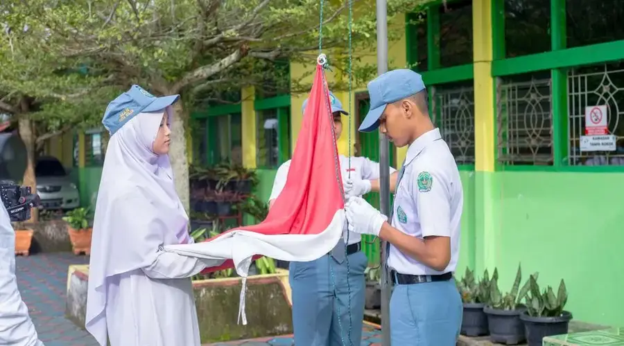 High school students participate in a national flag-raising ceremony outdoors at school.