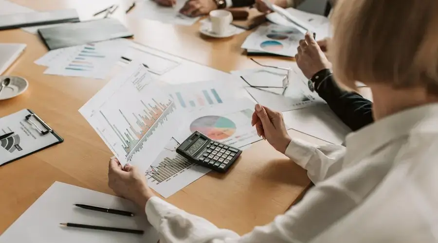 Business team analyzing financial data and graphs during a meeting to strategize growth.