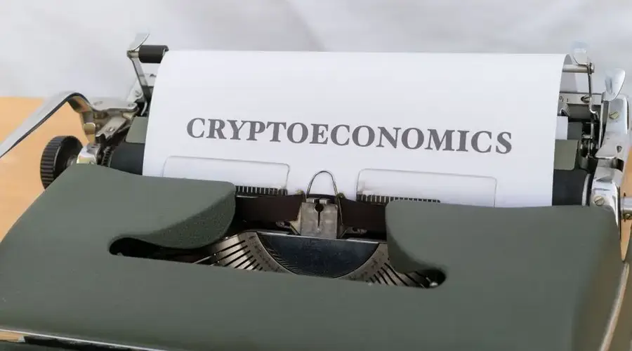 A vintage typewriter printing the term 'Cryptoeconomics', blending old technology with modern finance.