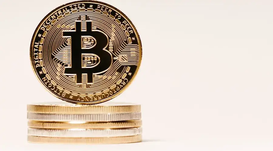A close-up image of Bitcoin cryptocurrency coins stacked on a neutral background, perfect for financial themes.