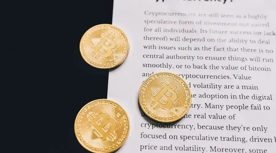 Gold Bitcoin coins on top of a cryptocurrency investment guide. High-quality finance and cryptocurrency image.