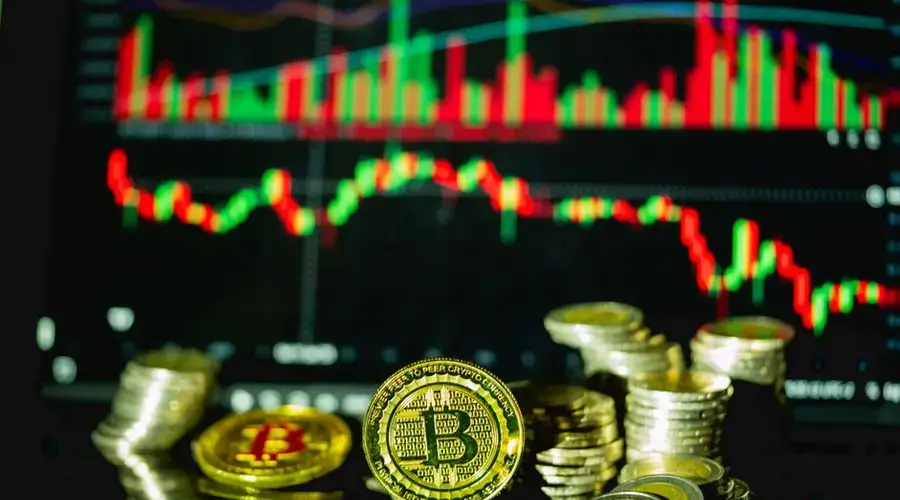 Golden bitcoins stacked in front of a fluctuating financial chart, symbolizing cryptocurrency trading.