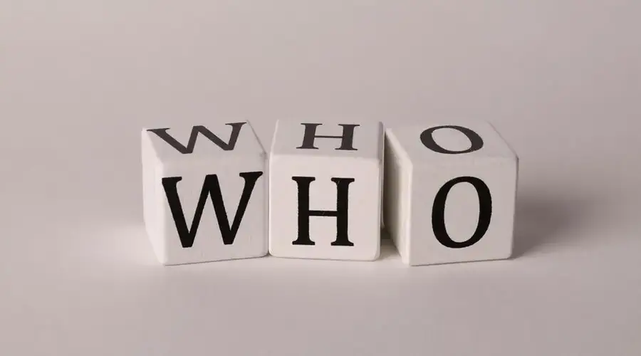 Three wooden alphabet blocks spelling 'WHO' on a white background, perfect for word games or educational content.