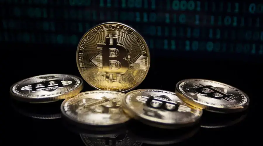 Close-up of gold Bitcoin coins against a digital binary code background, symbolizing modern finance.