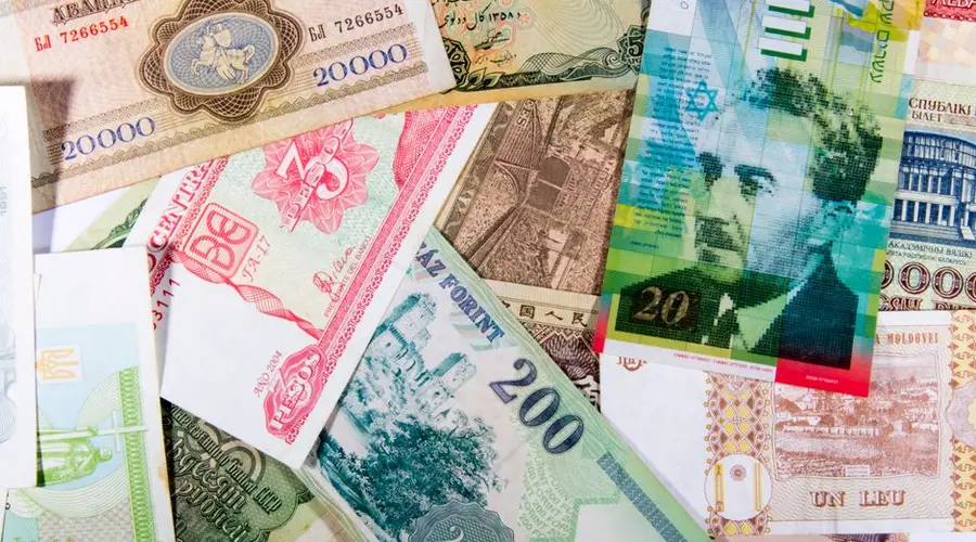 Colorful assortment of international paper currencies from various countries in a flat lay.
