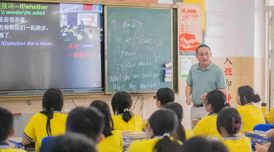 Asian teacher conducts an English lesson in a classroom with students.