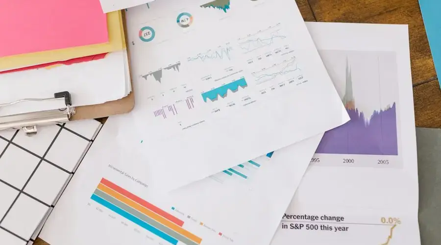 Close-up of business analytics charts and graphs on papers and clipboard.