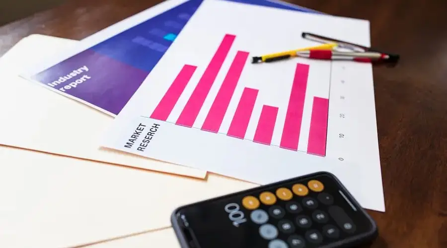 Illustrative market research chart and calculator on wooden desk for business analysis.