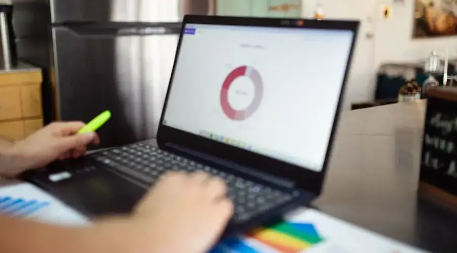 Person analyzing business data on a laptop in a modern indoor setting.