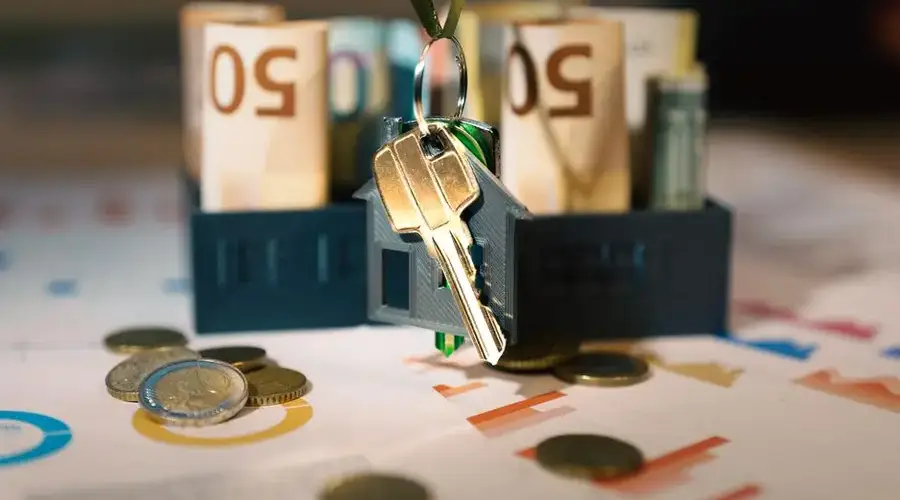 Keys hanging with money and charts, symbolizing real estate investment and financial planning.