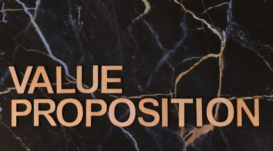 Wooden letters spelling 'Value Proposition' on a marble background, symbolizing business strategy.