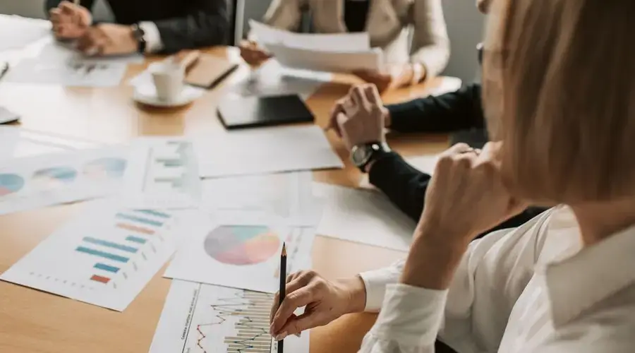 Business professionals reviewing charts and graphs during a meeting in office setting.