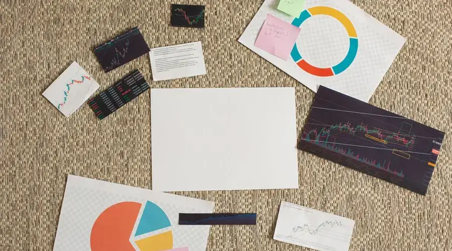 Flat lay of financial charts and sticky notes on a textured surface, ideal for planning and analysis concepts.