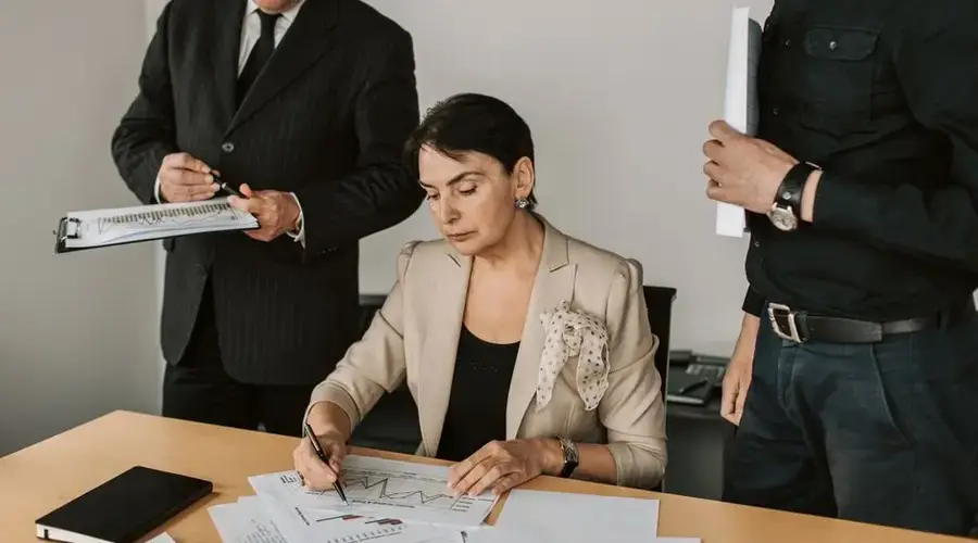 Business professionals collaborating on financial documents in an office setting.