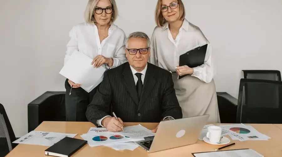 Senior professionals in a business meeting, discussing charts and data in the office.