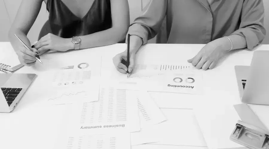 Two professionals analyzing financial documents in a modern office setting.