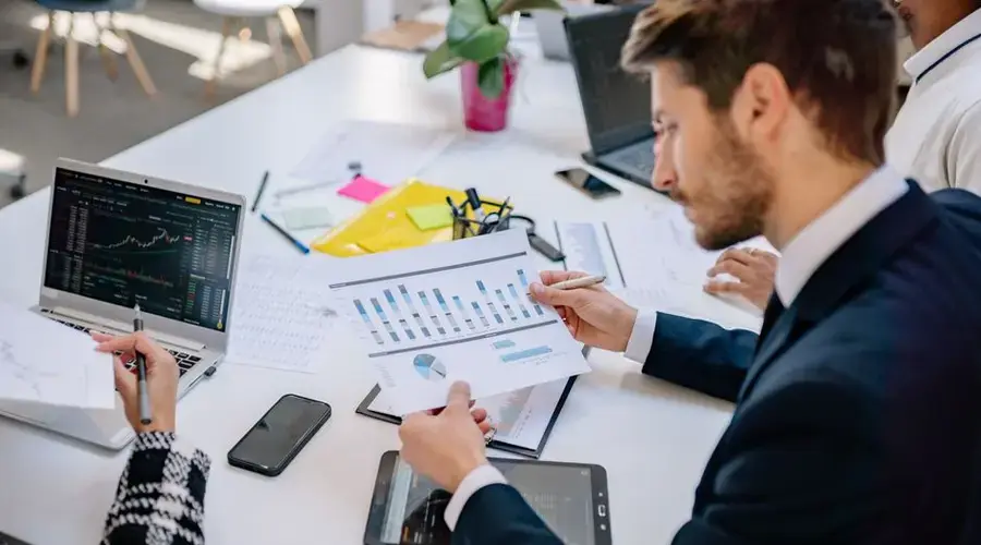 Business team reviewing graphs and data in an office setting.