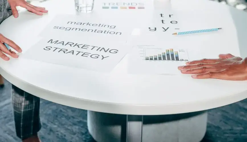 Two professionals collaborate on marketing strategy and segmentation at a round table.