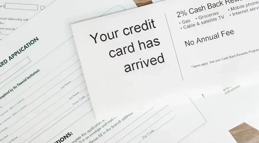 Close-up of a letter announcing the arrival of a credit card amidst financial documents.