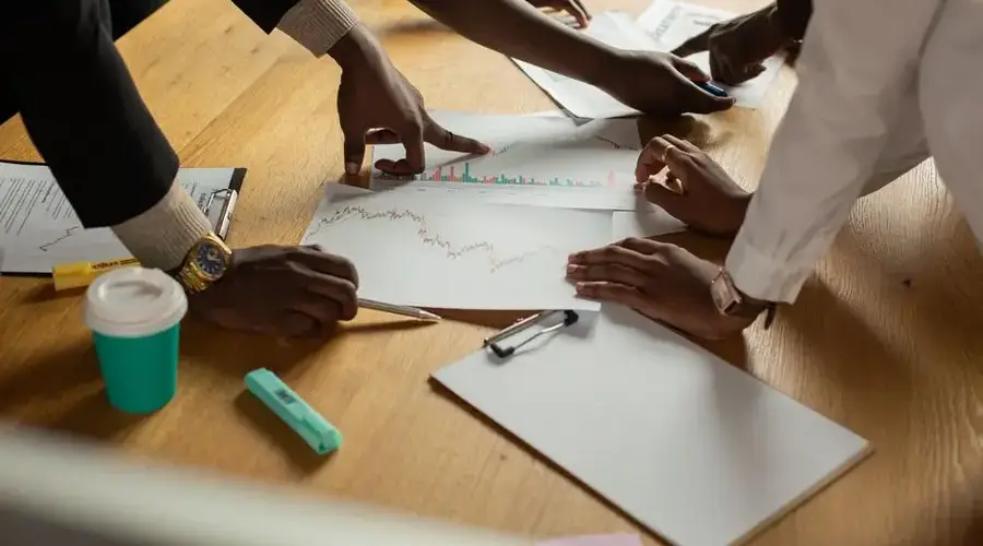 A diverse team collaborates on analyzing data charts during a meeting.