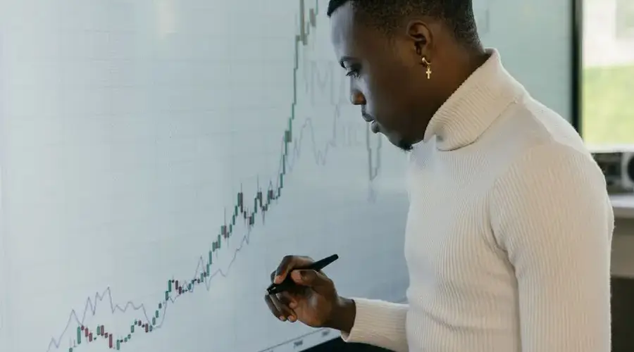 Young male strategist analyzing financial growth trends on a digital screen.