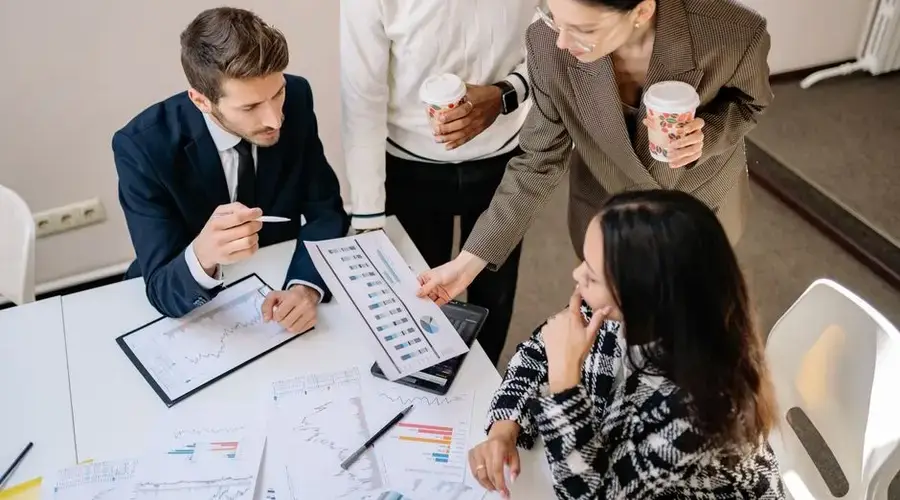 Four colleagues discuss data and strategy in an office setting.